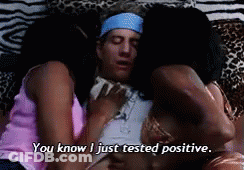 A Man Is Laying On A Bed With Two Women And The Words " You Know I Just Tested Positive " Above Him GIF