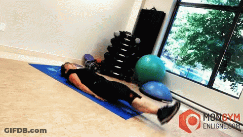 A Man Is Laying On A Blue Mat In A Gym With A Mongym Enligne.com Logo GIF