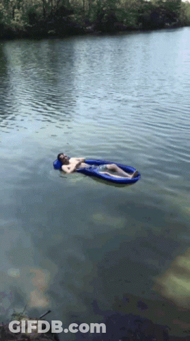 A Man Is Laying On A Blue Raft In The Water GIF