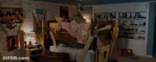 A Man Is Laying On A Bunk Bed In A Room With A Sign On The Wall That Says ' A ' On It GIF