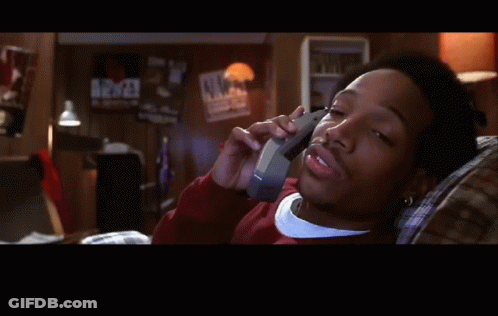 A Man Is Laying On A Couch Talking On A Cell Phone With The Word True Below Him GIF