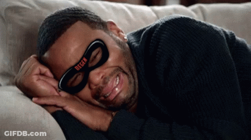 A Man Is Laying On A Couch Wearing A Mask That Says Degen On It GIF