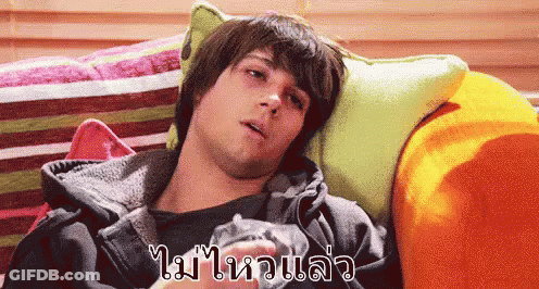 A Man Is Laying On A Couch With A Foreign Language Written On The Bottom Right GIF