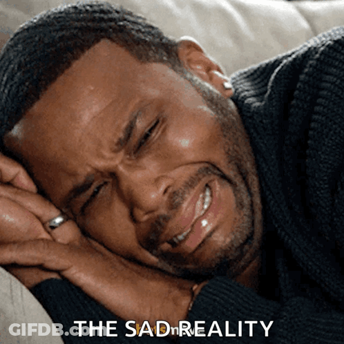 A Man Is Laying On A Couch With His Eyes Closed And The Words " The Sad Reality " Next To Him GIF