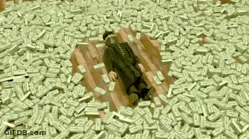 A Man Is Laying On A Pile Of Money On The Floor . GIF