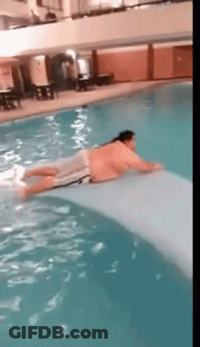 A Man Is Laying On A Raft In A Pool GIF