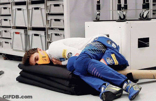 A Man Is Laying On A Stack Of Blankets With A Mask On His Face That Says ' Ferrari ' GIF