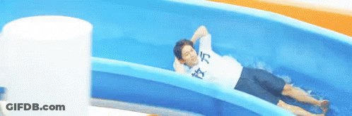 A Man Is Laying On A Water Slide Wearing A Shirt That Says ' I 'M Tired ' On It GIF