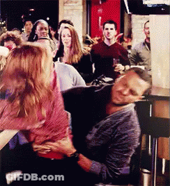 A Man Is Laying On A Woman 'S Lap In A Crowd Of People GIF