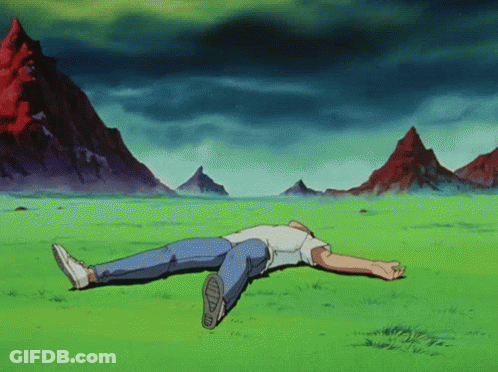 A Man Is Laying On His Back In A Grassy Field With Mountains In The Background GIF