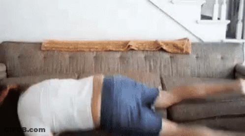 A Man Is Laying On His Stomach On A Couch Doing Push Ups . GIF