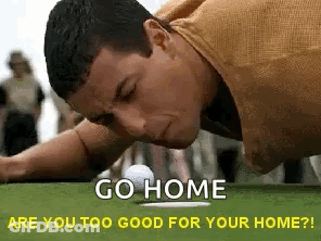 A Man Is Laying On His Stomach On A Golf Course With A Golf Ball . GIF