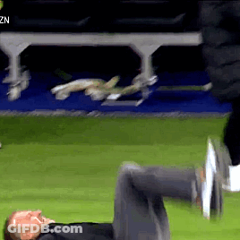 A Man Is Laying On His Stomach On A Soccer Field GIF