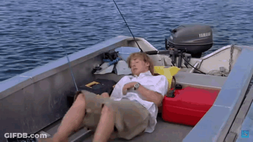 A Man Is Laying On The Deck Of A Boat With A Yamaha Motor GIF
