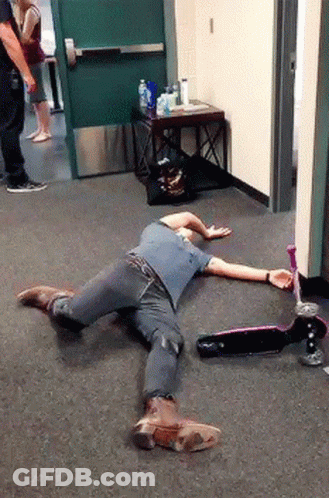 A Man Is Laying On The Floor Next To A Scooter And A Bottle Of Water GIF