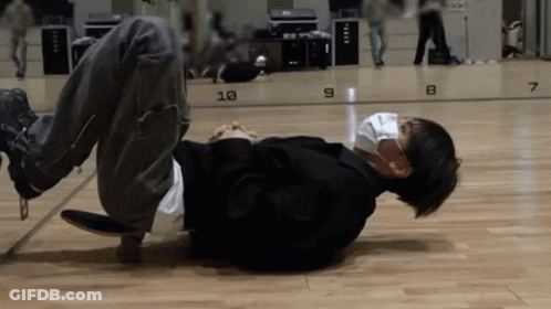 A Man Is Laying On The Floor Wearing A Mask And Headphones GIF