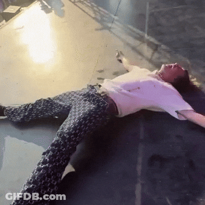 A Man Is Laying On The Floor With His Arms Outstretched GIF