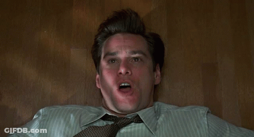 A Man Is Laying On The Floor With His Hands On His Face . GIF