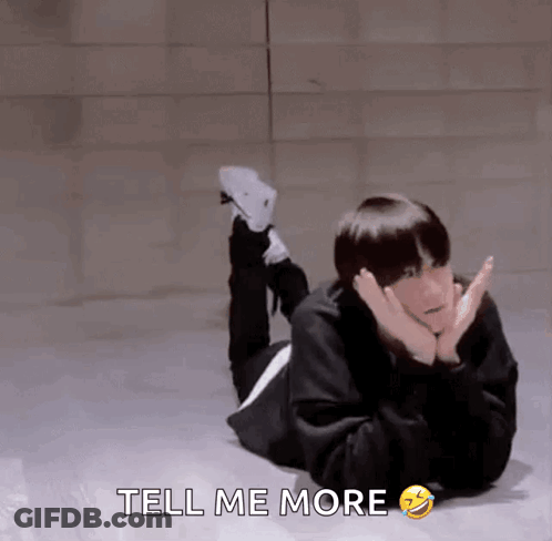 A Man Is Laying On The Floor With His Legs Crossed And The Words Tell Me More Below Him GIF