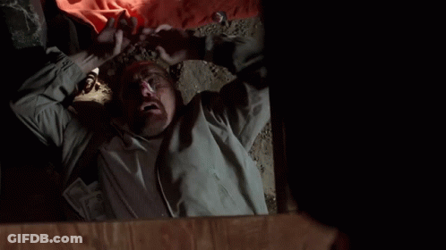 A Man Is Laying On The Floor With His Mouth Open And His Hands In The Air . GIF