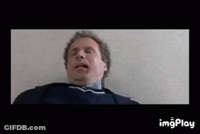 A Man Is Laying On The Floor With His Mouth Open And His Tongue Out . GIF