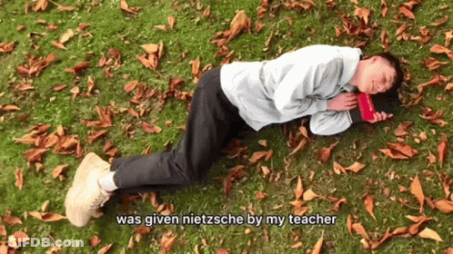A Man Is Laying On The Grass With A Book And The Words Was Given Nietzsche By My Teacher GIF