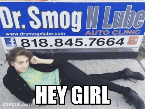 A Man Is Laying On The Ground In Front Of A Sign For Dr. Smog N Lube Auto Clinic GIF