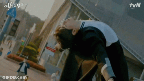 A Man Is Laying On The Ground In Front Of A Tvn Building . GIF
