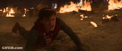 A Man Is Laying On The Ground In Front Of Fires GIF