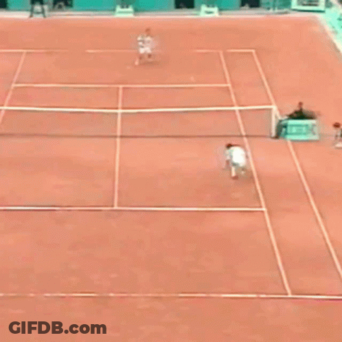 A Man Is Laying On The Ground On A Tennis Court GIF