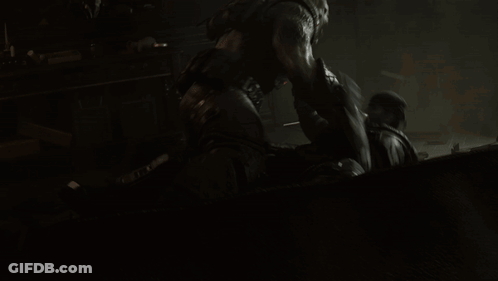 A Man Is Laying On The Ground While Another Man Stands Behind Him GIF