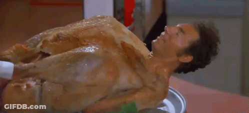 A Man Is Laying On Top Of A Roasted Turkey GIF