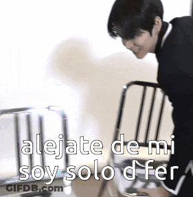 A Man Is Leaning Over A Chair With The Words " Alejate De Mi Soy Solo D Fer " Written On It GIF