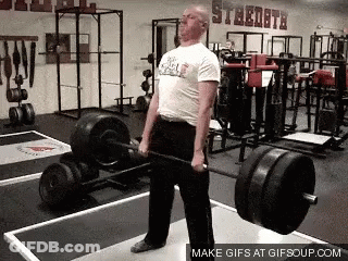 A Man Is Lifting A Barbell In A Gym That Has The Word Steeldata On The Wall GIF