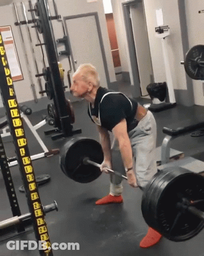A Man Is Lifting A Barbell In A Gym With A Barbell Rack That Says ' A ' On It GIF