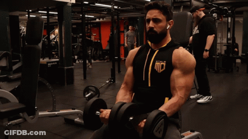Man Lifting Dumbbell In Gym Wearing MC Shirt GIF