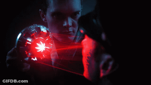 A Man Is Looking At Another Man With A Red Light Coming Out Of His Face GIF