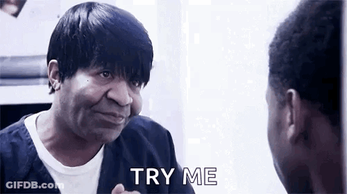 A Man Is Looking At Himself In A Mirror And Saying `` Try Me '' While Talking To Another Man . GIF