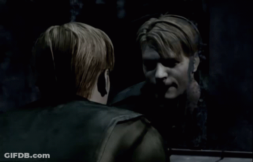 A Man Is Looking At His Reflection In A Dark Room GIF