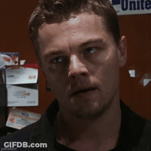 A Man Is Looking At The Camera With A Unite Sign In The Background GIF