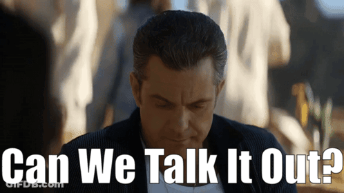 A Man Is Looking Down With The Words Can We Talk It Out Behind Him GIF