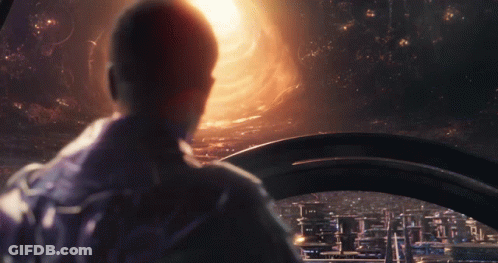 A Man Is Looking Out A Window At A City GIF