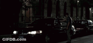 A Man Is Looking Out Of A Window With A Blurry Background Of Arrows GIF