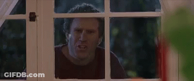 A Man Is Looking Out Of A Window With A Serious Look On His Face . GIF