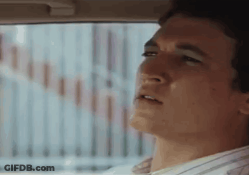 A Man Is Looking Out The Window Of A Car . GIF