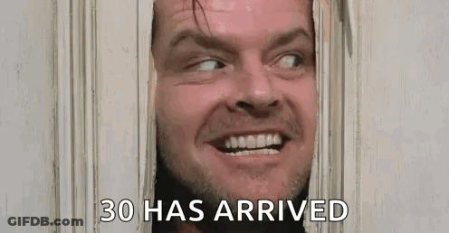 A Man Is Looking Through A Door With The Words `` 30 Has Arrived '' Written Below Him . GIF