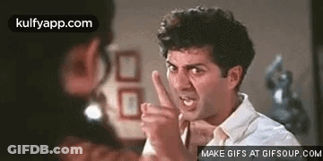 A Man Is Making A Funny Face And Pointing His Finger At Another Man . GIF