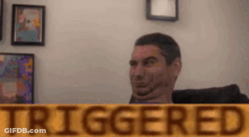 A Man Is Making A Funny Face Behind A Sign That Says Triggered . GIF