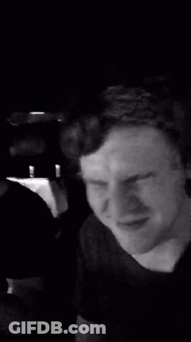 A Man Is Making A Funny Face In A Black And White Photo While Sitting In A Car . GIF