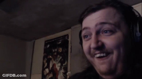 A Man Is Making A Funny Face In A Dark Room . GIF